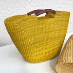 Handwoven Bolga basket bag made from elephant grass with leather handle, crafted in Ghana