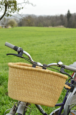 
                  
                    a natural color bolga bike basket attached to the bike handle,
                  
                