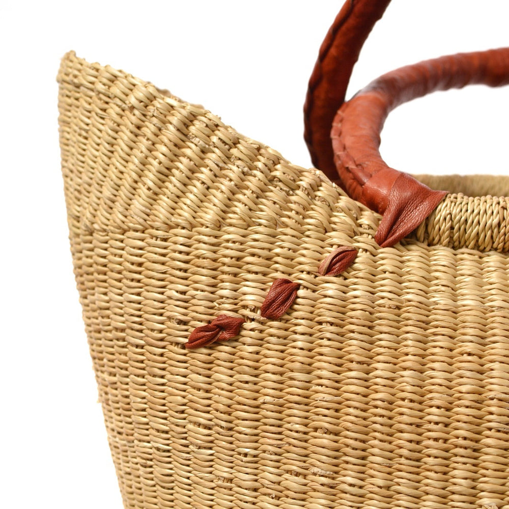 
                  
                    details of woven natural basket with leather handles
                  
                