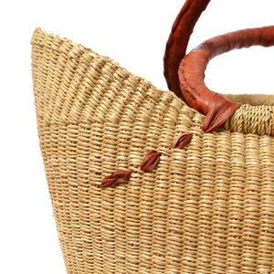 
                  
                    details of woven natural basket with leather handles
                  
                