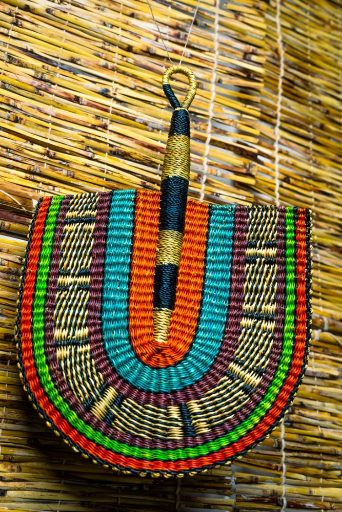 colorful bolga fan hanging on a bamboo blinds