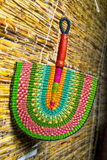 colorful bolga fan with leather handle on a bamboo blinds