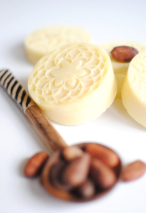 
                  
                    cooca butter lotion bar with cocoa beans on a spoon
                  
                